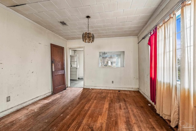 spare room with ornamental molding and dark hardwood / wood-style floors