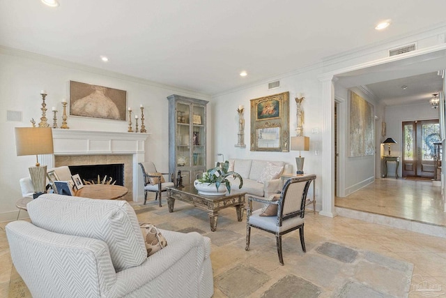 living room with crown molding, visible vents, a fireplace, and light tile patterned flooring