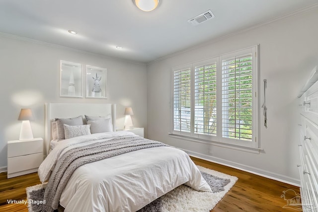 bedroom featuring dark wood-style floors, ornamental molding, multiple windows, and visible vents