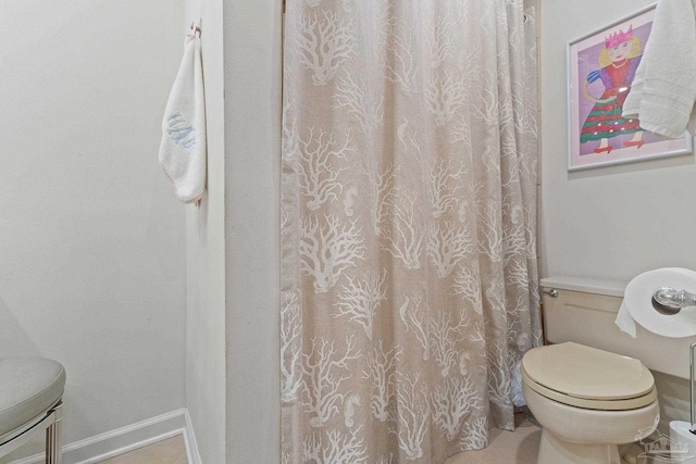 full bath featuring toilet and baseboards