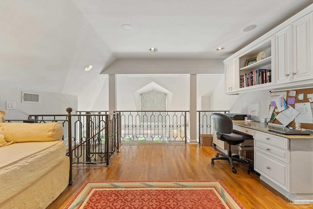 office space with vaulted ceiling and light wood-type flooring