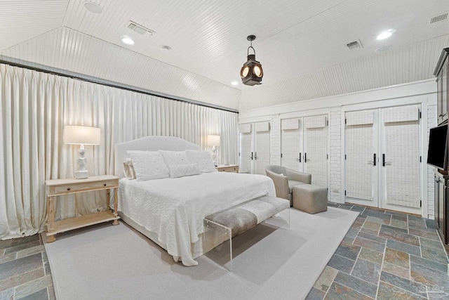 bedroom with dark tile patterned floors, vaulted ceiling, and french doors