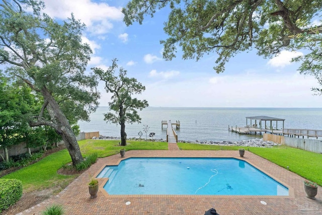 outdoor pool featuring a dock, a water view, fence, and a lawn