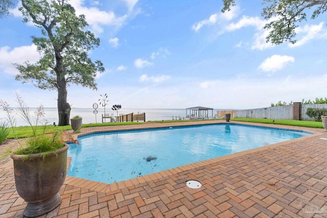 view of swimming pool featuring a water view, fence, and a fenced in pool