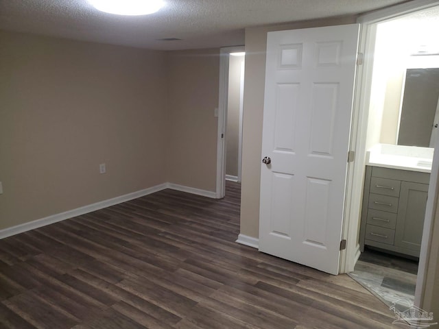 interior space with dark wood-style floors, baseboards, and a textured ceiling