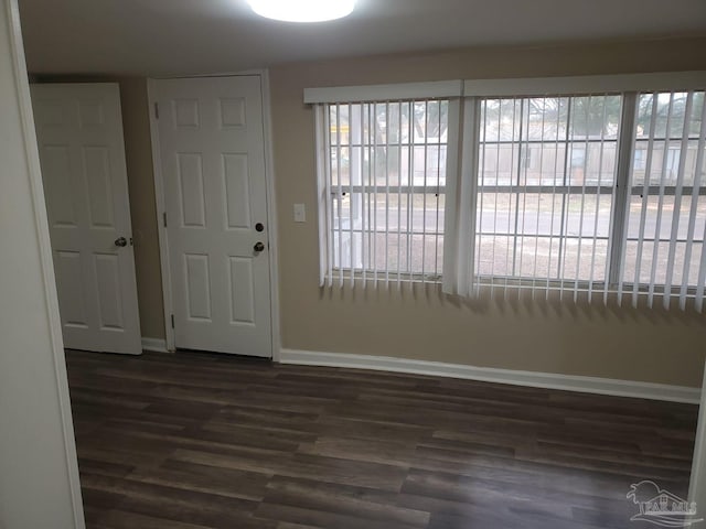 foyer entrance featuring dark wood-style floors and baseboards