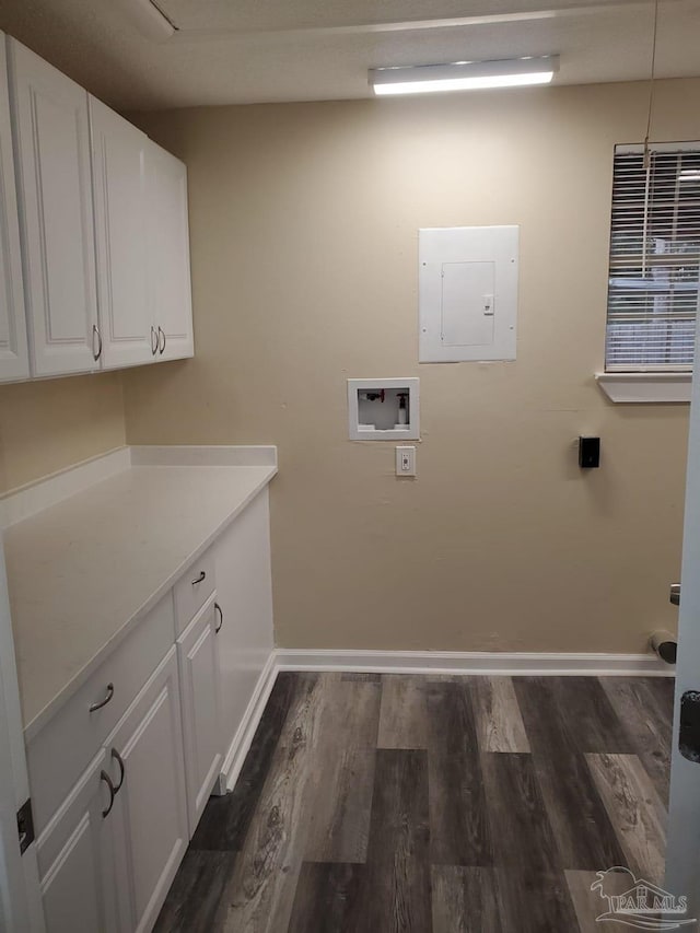 clothes washing area featuring baseboards, electric panel, cabinet space, dark wood-style flooring, and washer hookup