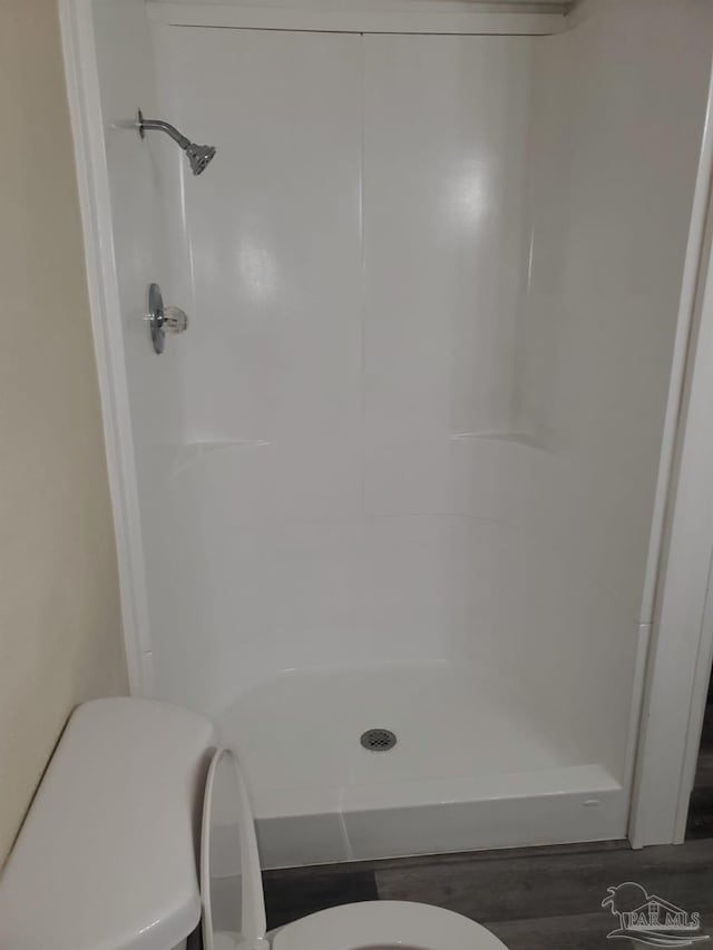 full bath featuring toilet and a shower stall