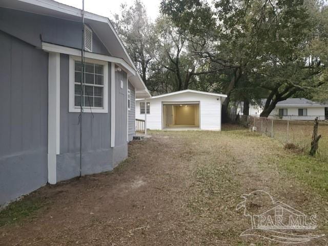 view of yard featuring an outbuilding and fence