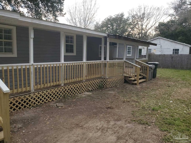 rear view of house with a wooden deck and fence