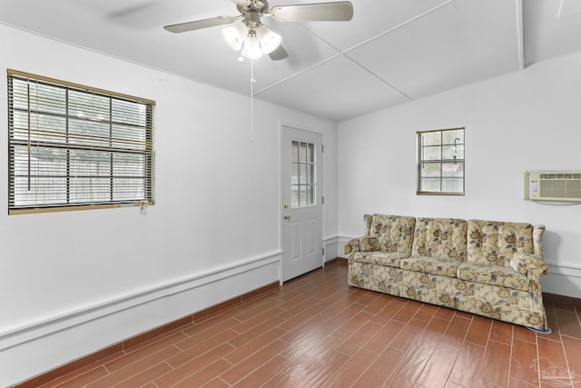 living room featuring ceiling fan, dark wood-type flooring, a wall unit AC, and a baseboard radiator