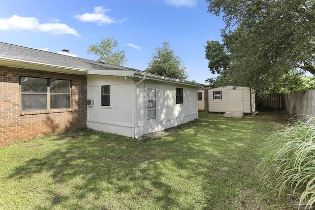 rear view of house with a yard and a storage shed