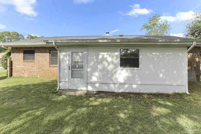 rear view of property with a yard