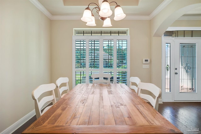 dining area with a notable chandelier, crown molding, dark wood-type flooring, and a wealth of natural light