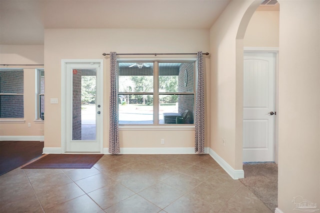 entryway with light tile patterned flooring and a wealth of natural light