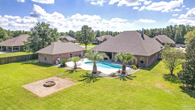 view of swimming pool with a fire pit, a lawn, and a patio area