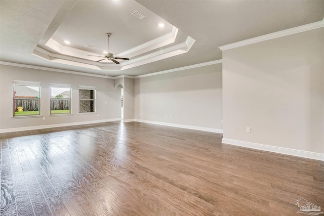 unfurnished room featuring ornamental molding, hardwood / wood-style floors, ceiling fan, and a tray ceiling