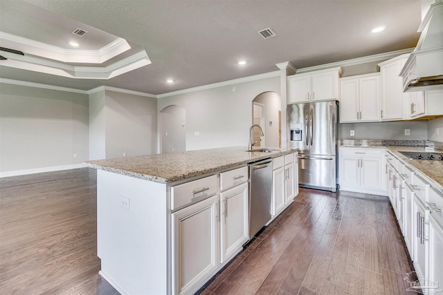 kitchen featuring sink, crown molding, stainless steel appliances, and an island with sink