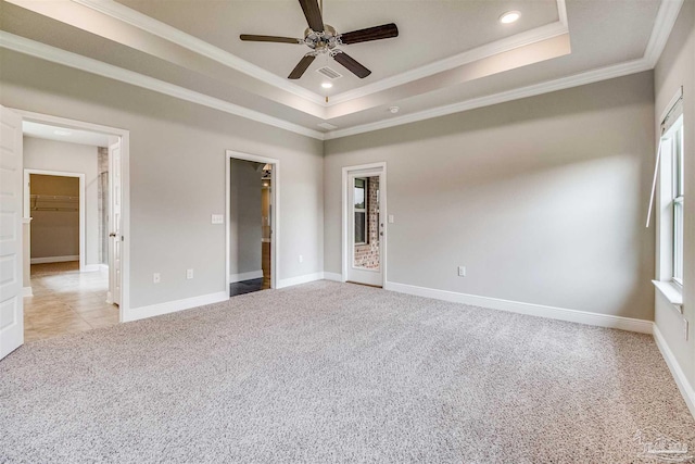 carpeted empty room with crown molding, a raised ceiling, and ceiling fan