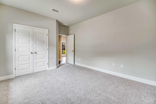 unfurnished bedroom featuring carpet flooring and a closet