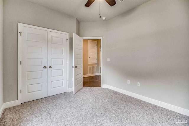 unfurnished bedroom with ceiling fan, carpet flooring, and a closet