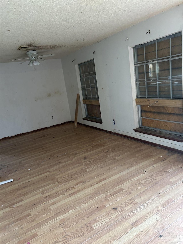 unfurnished room featuring a textured ceiling and light wood-type flooring