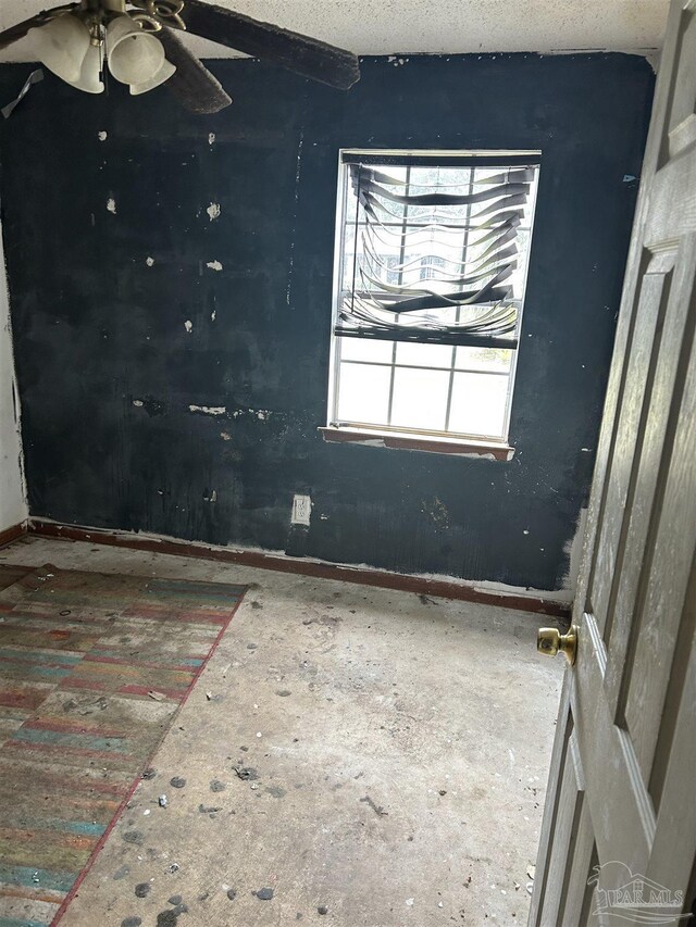 empty room featuring ceiling fan and a textured ceiling