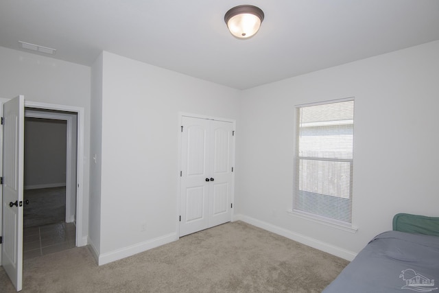 bedroom with a closet and light colored carpet