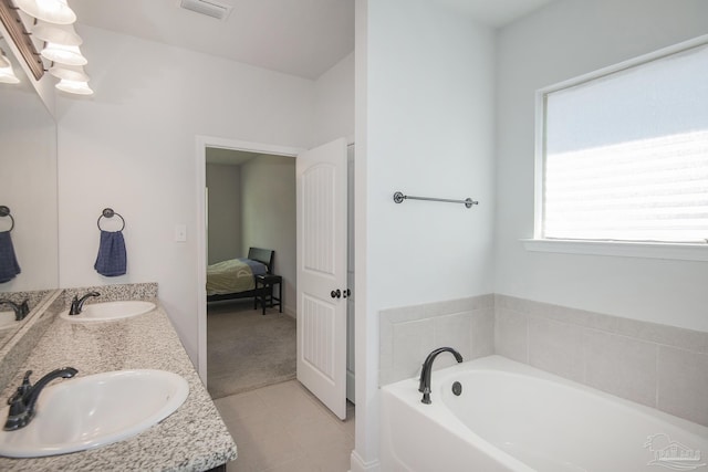 bathroom with tile patterned floors, a bathing tub, and vanity