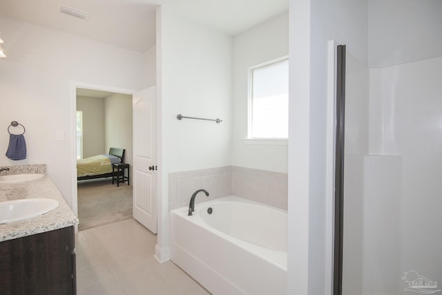 bathroom featuring tile patterned flooring, vanity, and a bath