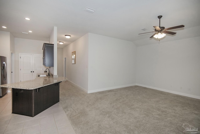 kitchen featuring stainless steel fridge, light colored carpet, ceiling fan, sink, and lofted ceiling