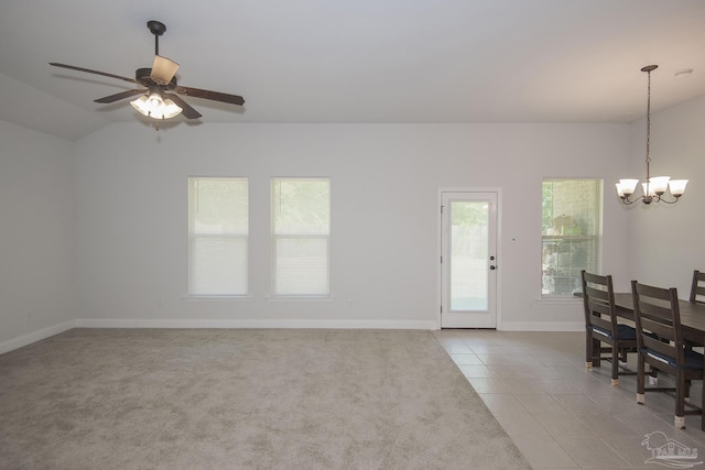 interior space with light tile patterned flooring and ceiling fan with notable chandelier