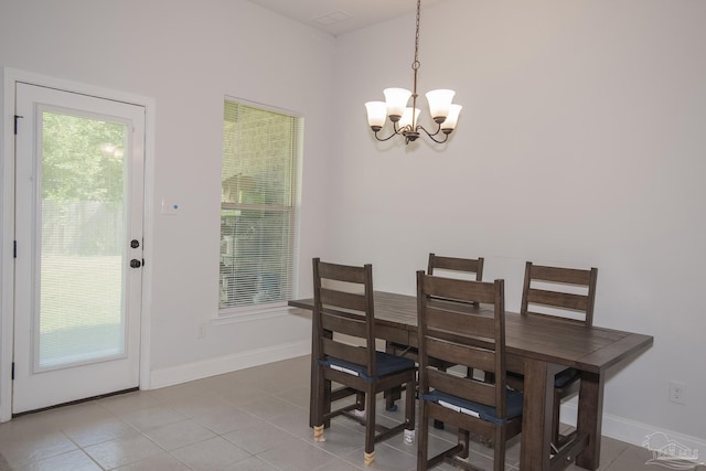 dining space with tile patterned floors and an inviting chandelier