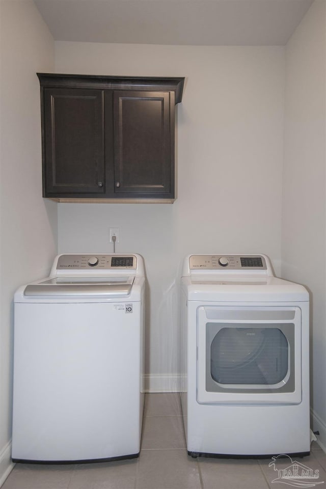 laundry area featuring cabinets, independent washer and dryer, and light tile patterned flooring