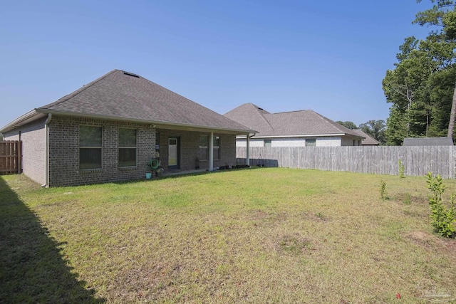 rear view of house featuring a lawn