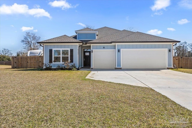 view of front of home featuring a garage, driveway, fence, a front lawn, and board and batten siding