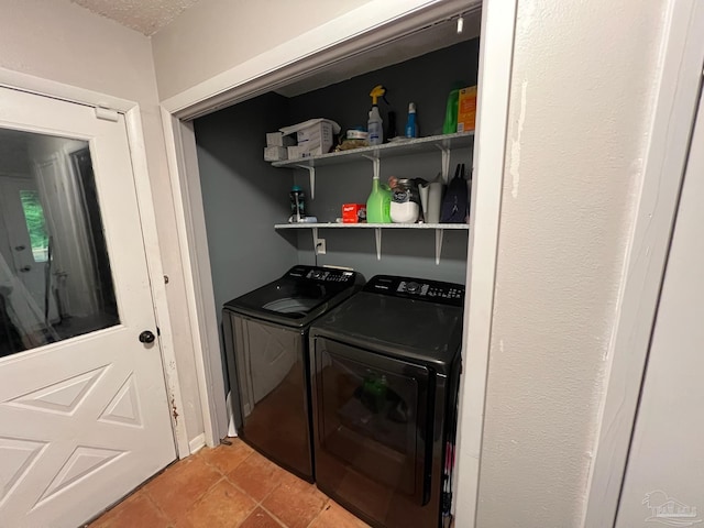 laundry room with washing machine and clothes dryer and light tile patterned flooring