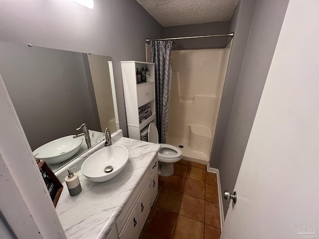 bathroom with a textured ceiling, vanity, a shower with curtain, and toilet