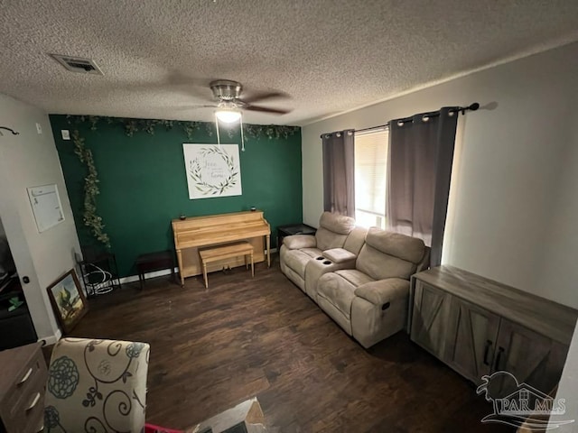 living room with a textured ceiling, ceiling fan, and dark hardwood / wood-style flooring