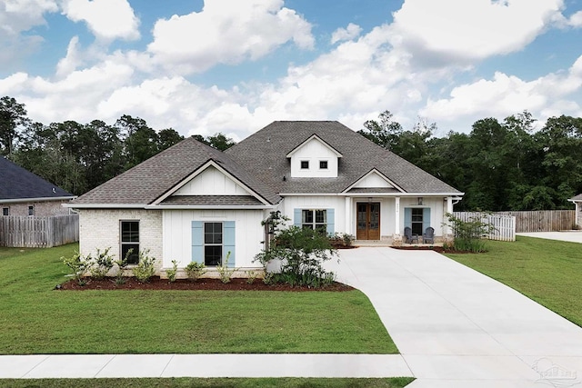 view of front of house with fence, driveway, and a front lawn