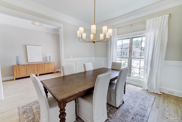 dining room featuring crown molding, an inviting chandelier, radiator heating unit, and a wainscoted wall