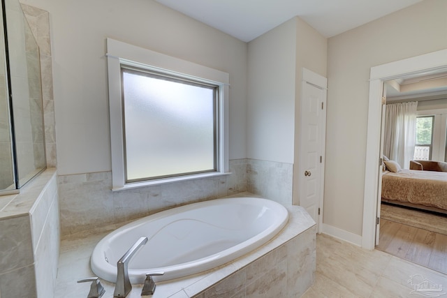 ensuite bathroom featuring a garden tub and connected bathroom