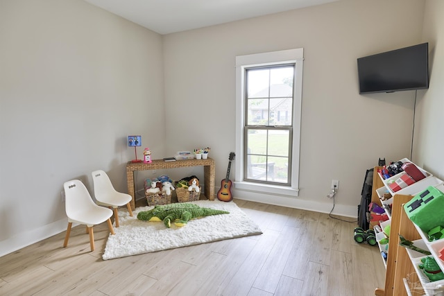living area with baseboards and wood finished floors