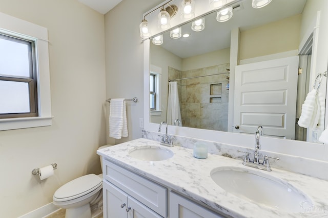 bathroom featuring a sink, toilet, and a healthy amount of sunlight