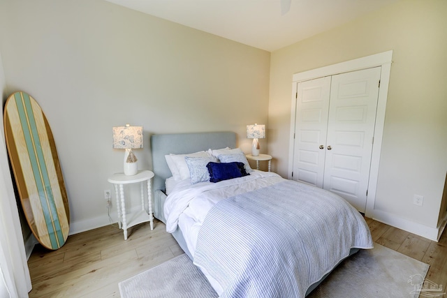 bedroom featuring a closet, light wood finished floors, and baseboards