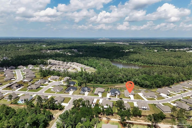 drone / aerial view with a residential view, a water view, and a wooded view