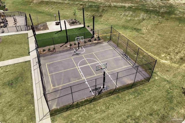 view of sport court with fence, community basketball court, and a lawn