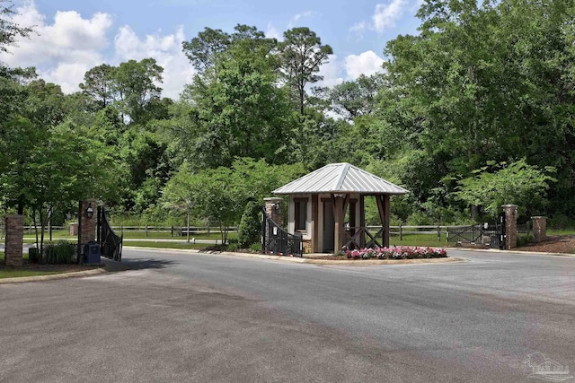 view of street with curbs and a gated entry