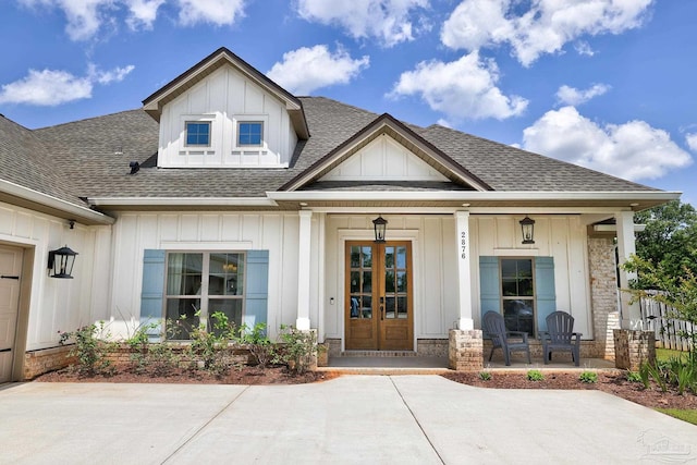 property entrance featuring board and batten siding, a shingled roof, and covered porch