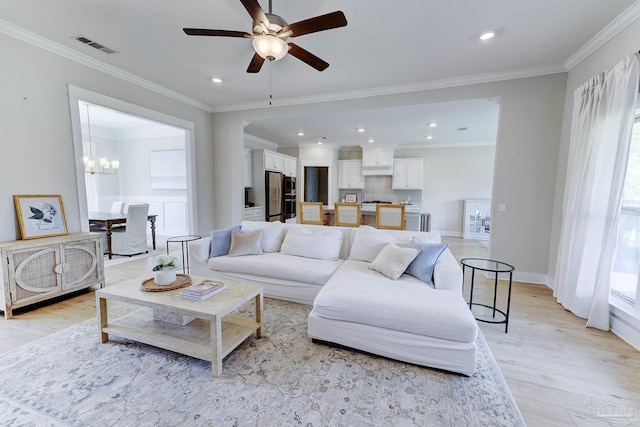 living area with light wood-style floors, crown molding, ceiling fan with notable chandelier, and visible vents